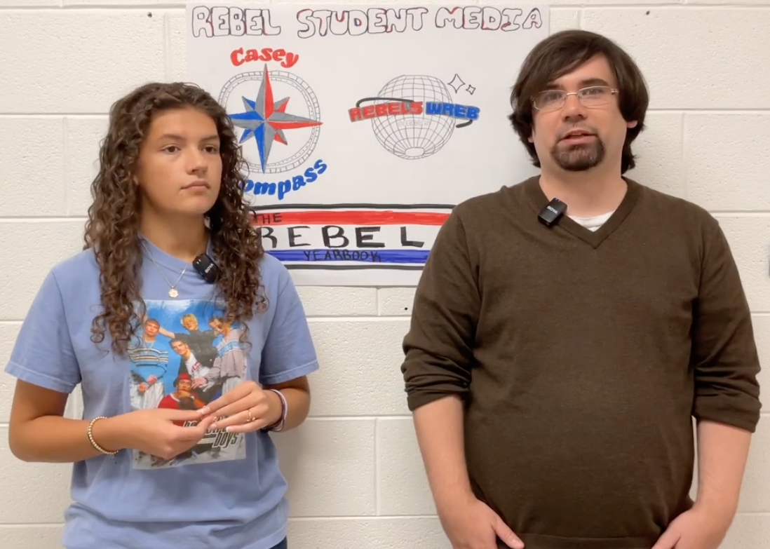 Editor-in-chief Aubrey Melton (left) and advisor John Overby discuss the Casey Compass.
